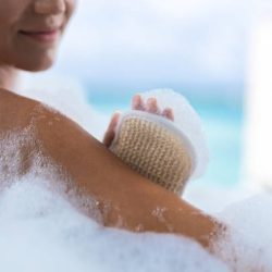 Close up of unrecognizable woman using bath sponge during her bath.